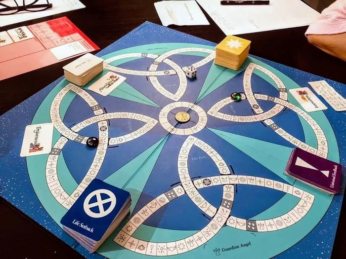 A Transformation Game board with cards, dice and playing pieces on a table