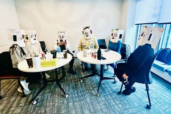 Workshop participants wearing decorated boxes on their heads during The Box © exercise